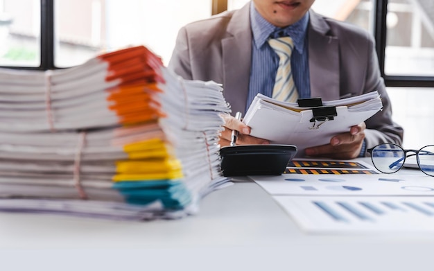 Stack of documents pile of papers on office desk employee's table closeup Asian people