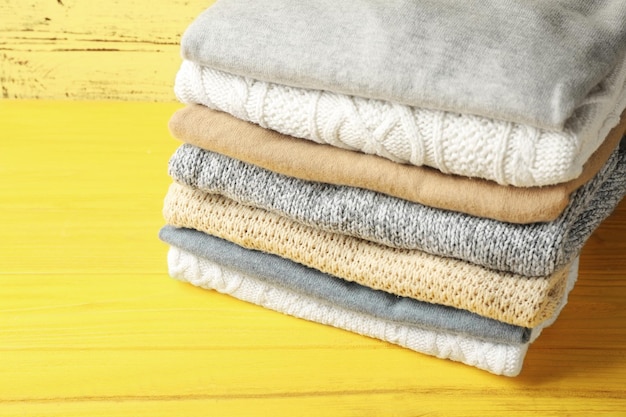 Stack of folded clothes on wooden background