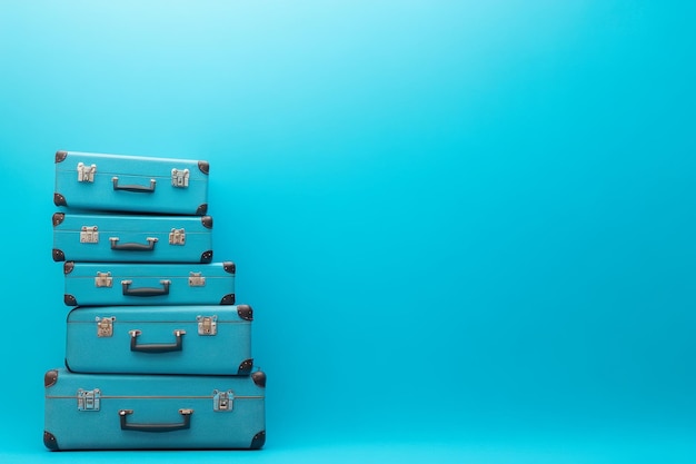 Photo a stack of four blue suitcases on a vibrant blue background symbolizing travel adventure vac