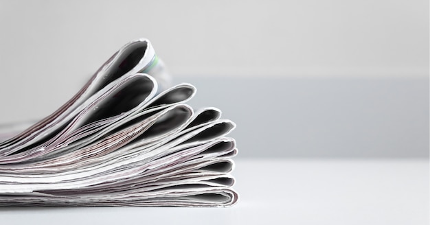 A stack of fresh newspapers on a gray background. News