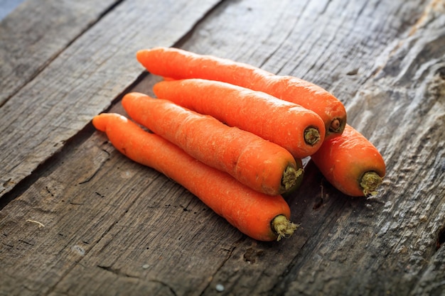 Stack of fresh orange carrots on wooden surface