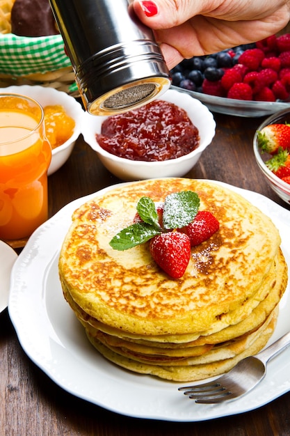 stack of freshly prepared traditional pancakes with strawberries