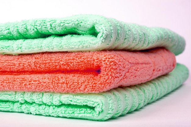 A stack of green and red terry towels folded in a stack