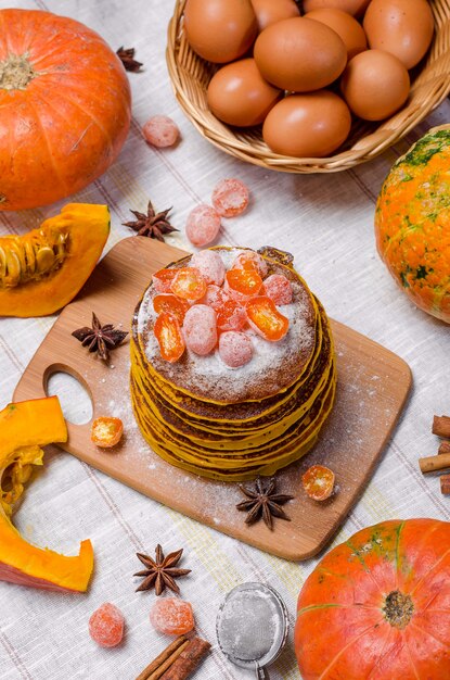 A stack of homemade pumpkin punkcakes with powdered sugar and candied kumquat 