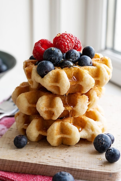 Stack of homemade waffles with raspberries and blueberries