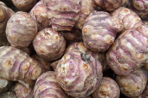 Photo stack of jerusalem artichokes on a market stall