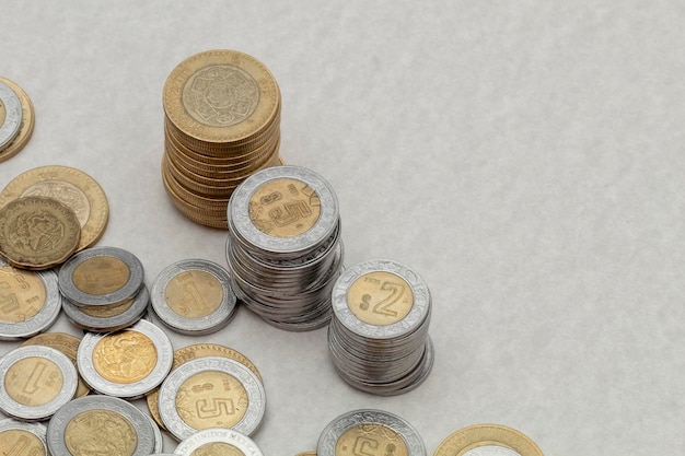 Stack of mexican peso coins of various denominations with copy space