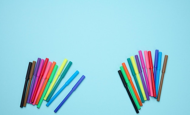 Stack of multicolored felttip pens on a blue background