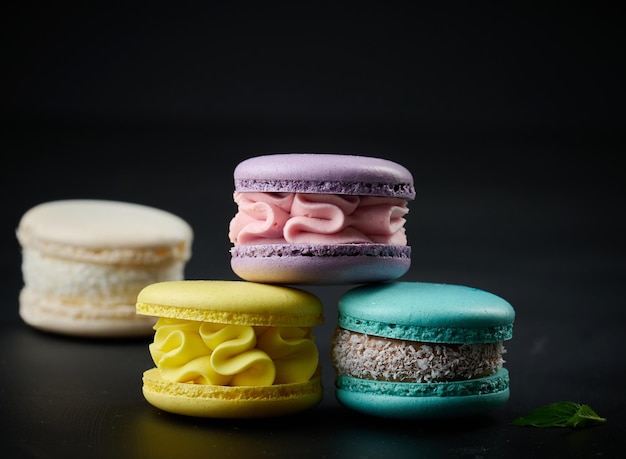 A stack of multicolored macaroons on a wooden board Delicious dessert