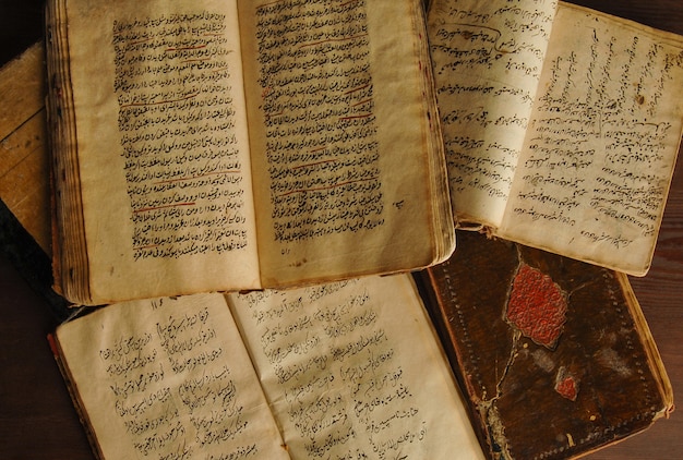 Stack of open ancient books in Arabic. Old Arabic manuscripts and texts. Top view