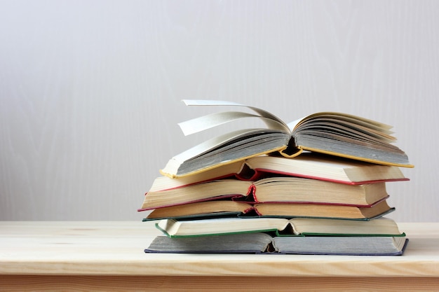 Stack of open paper books in hard color covers on the table