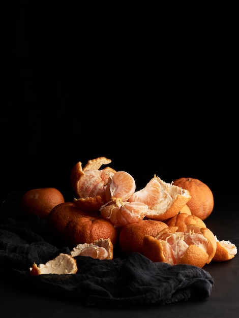 Stack of orange ripe mandarin on a black table