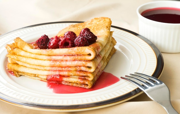 A stack of pancakes on a plate Pancakes topped with raspberry jam Image with selective focus