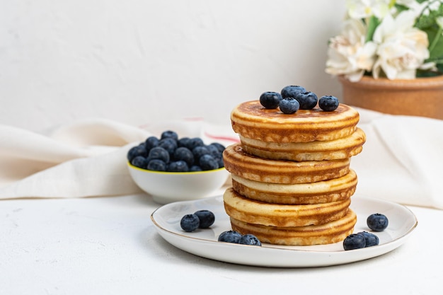 Stack of pancakes on plate with blueberries front view