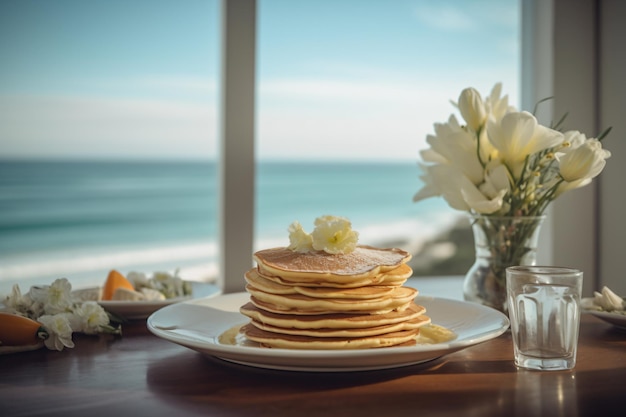 A stack of pancakes on a table with a vase of flowers in the background