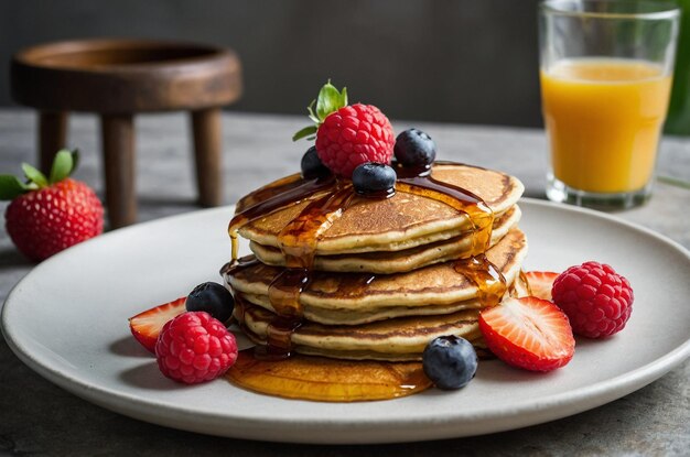 a stack of pancakes with berries and syrup on a plate