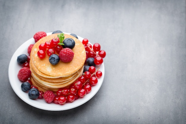 Stack of pancakes with blueberry and fresh berry.