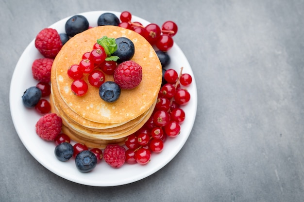 Stack of pancakes with blueberry and fresh berry.