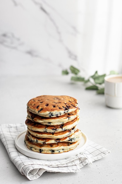 A stack of pancakes with fresh blueberries inside on marble Delicious homemade breakfast