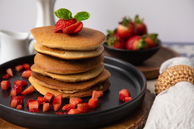 Photo a stack of pancakes with strawberries on top of them