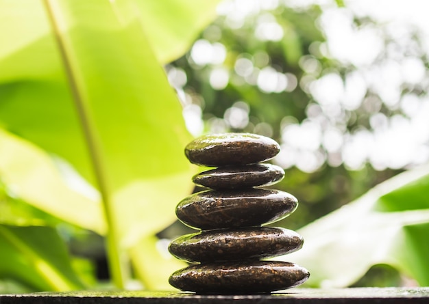 Stack pyramid stone zen pebbles nature on wooden with blur green nater outdoor meditation tranquil calm still balance relax of buddhism religion or aroma therapy spa massage setzen garden concept