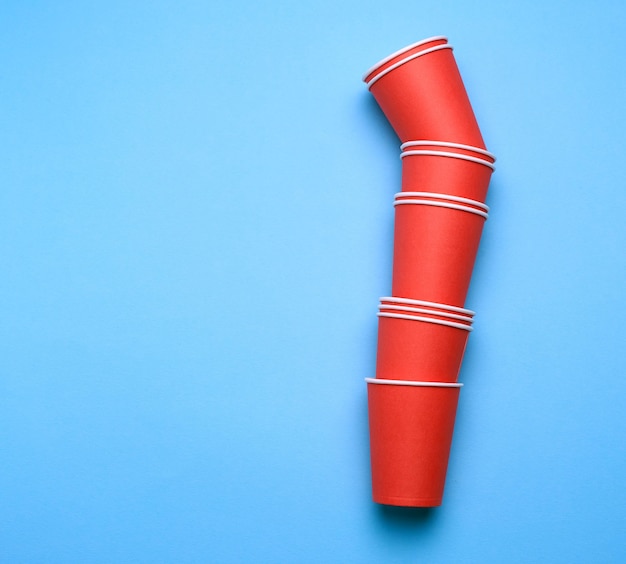 Photo stack of red paper disposable cups on a blue background flat lay concept eco-friendly zero waste