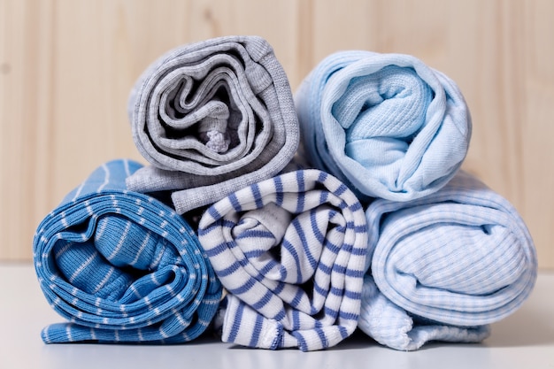 Stack rolled kid's clothes in blue colors