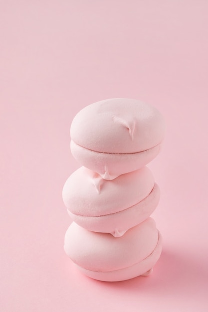 Stack of round pink marshmallows on pastel pink background closeup