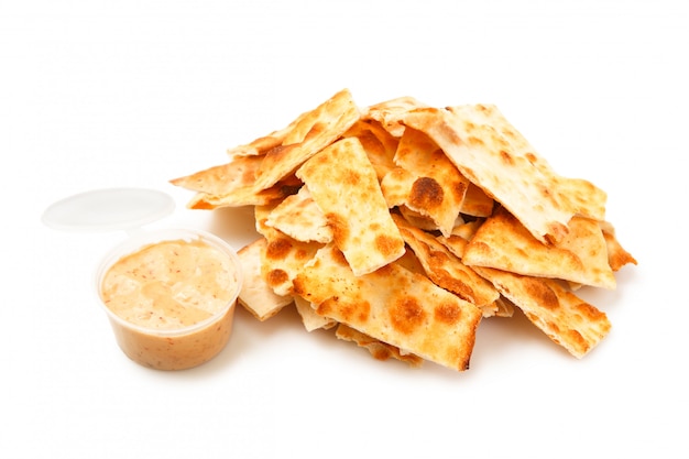 Stack of salted crackers and sauce inside of plastic package