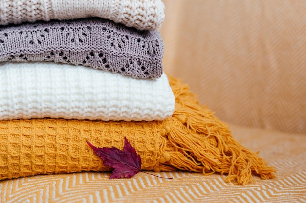 Stack of soft warm plaids and an autumn leaf closeup