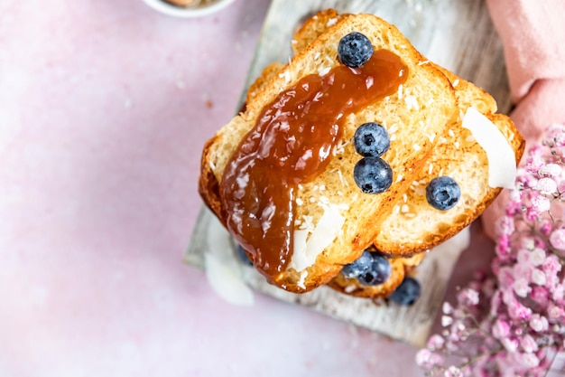 Stack of sweet french toasts with berries caramel sauce and coconut flakes Homemade brioche