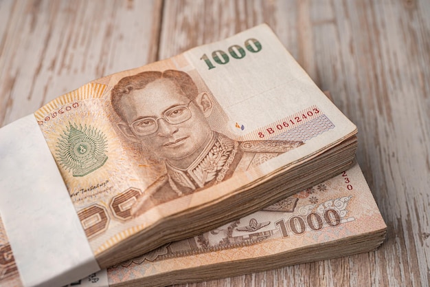 Stack of Thai baht banknotes on wooden background business saving finance investment concept