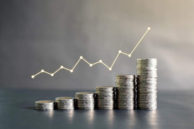 Stack of Thailand coins on black wooden table with profit graph, growth up, success. Business, finance, marketing, e-commerce concept and design