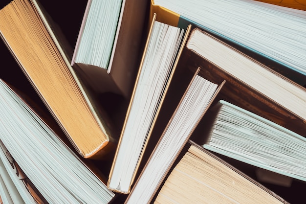 A stack of thick open books stand on a dark background. Back to school. Education background.