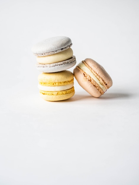 Stack of three fresh french pastel colorful macarons on white background. Copy space