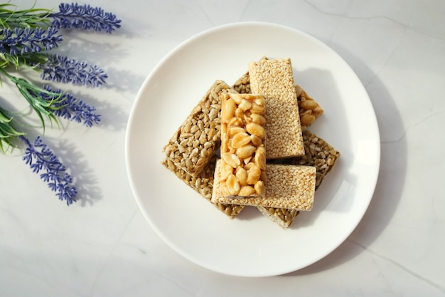 stack of traditional peanut brittle sweets on a white plate. Organic healthy product.