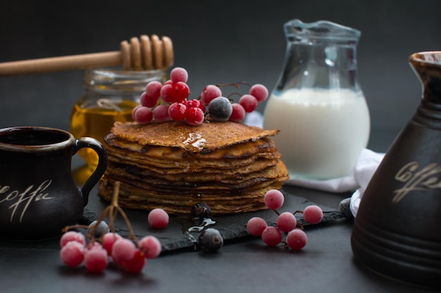 Stack of traditional Russian pancakes with honey on black background with Homemade Russian thin pancakes Russian national cuisine