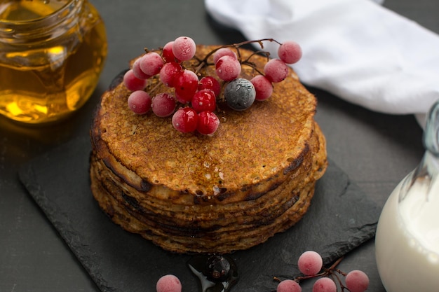 Stack of traditional Russian pancakes with honey on black background with Homemade Russian thin pancakes Russian national cuisine