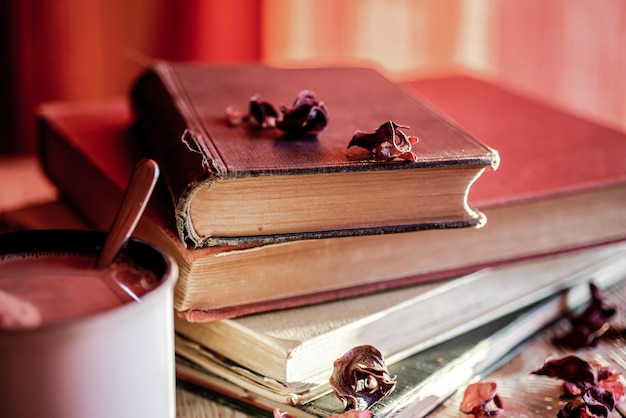 A stack of vintage books and a mug of hot chocolate concept of cozy place and pleasant reading