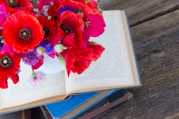 Stack of vintage old books  on table with field flowers