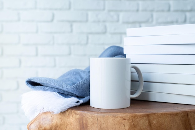 Stack of white blank books for mockup and white mugs on wooden modern table