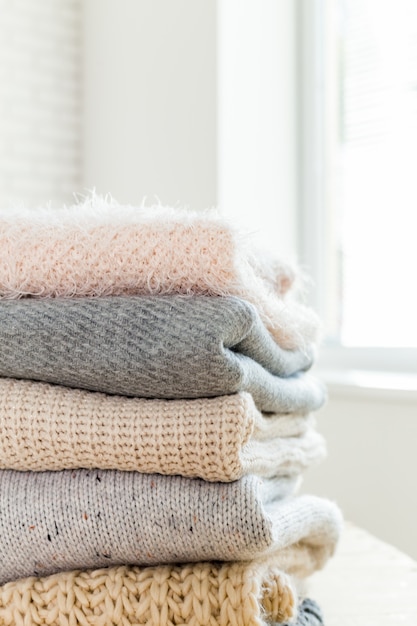 Stack of white cozy knitted sweaters