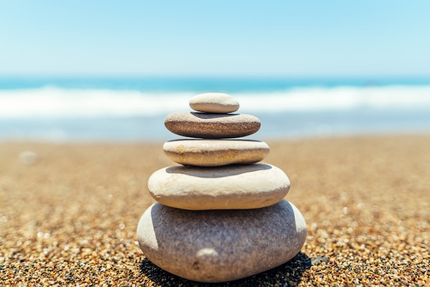 Stack of zen stones on the beach near sea