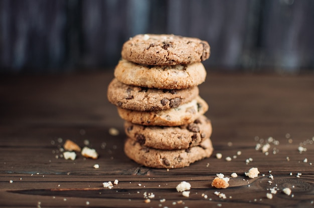 Stacked chocolate chip cookies on wooden rustic background in country style