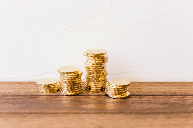 Stacked golden coins on wooden desk