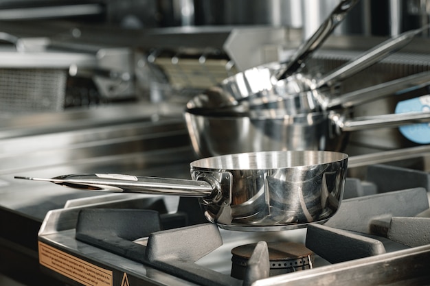 Stacked industrial metal cooking pots on proffesional kitchen