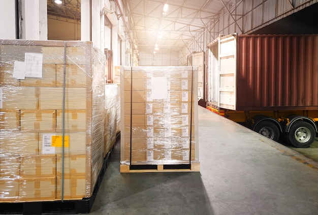 Stacked of shipment boxes on pallets waiting to load into container truck.