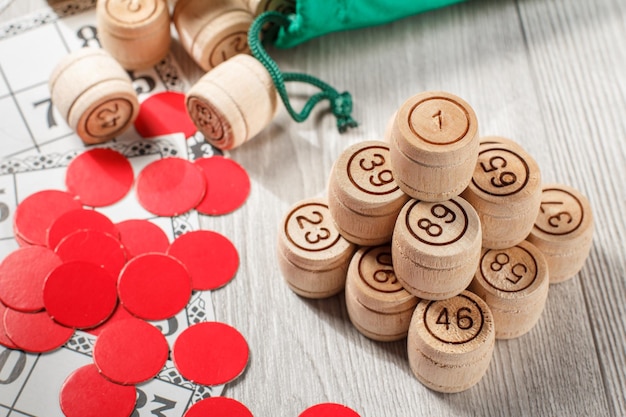 Stacked wooden lotto barrels game cards and red chops for a game in lotto