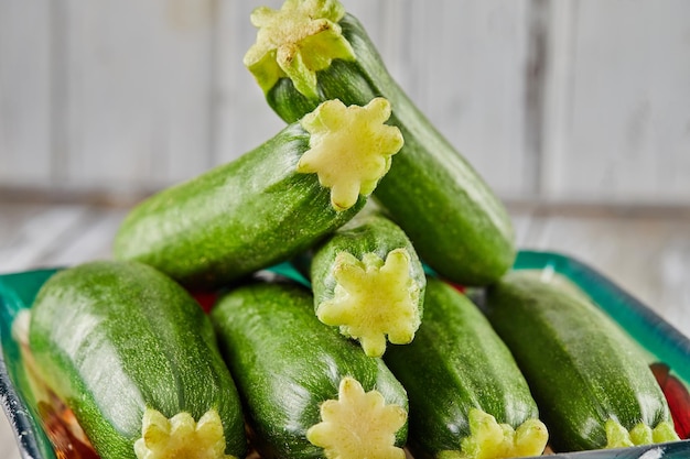 Stacked zucchini on plate on gray wooden background