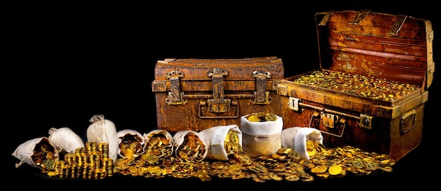 Stacking lots of gold coins in treasure chest old on black background